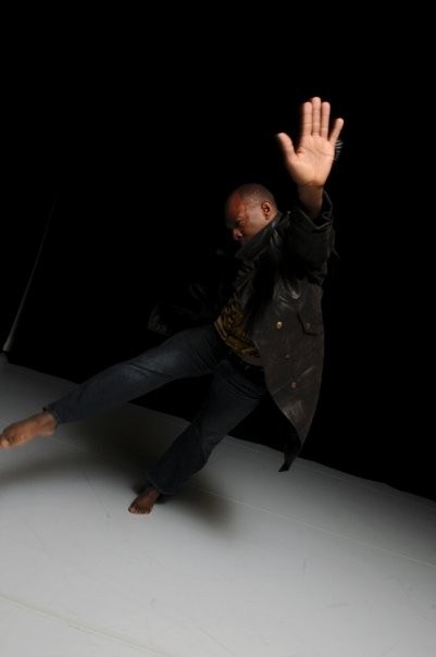 Boris Willis in a low angled pose, hand raised