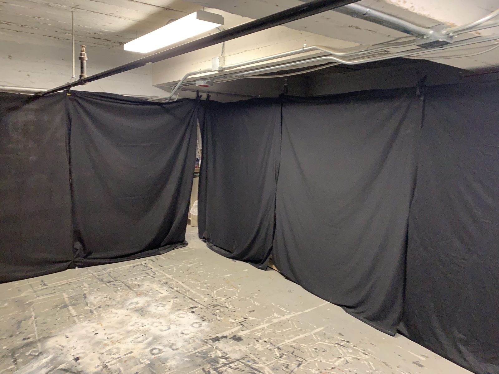 A blacked-out enclosure of dark drapes and a marked floor, the space where the dance is seen through night-vision goggles
