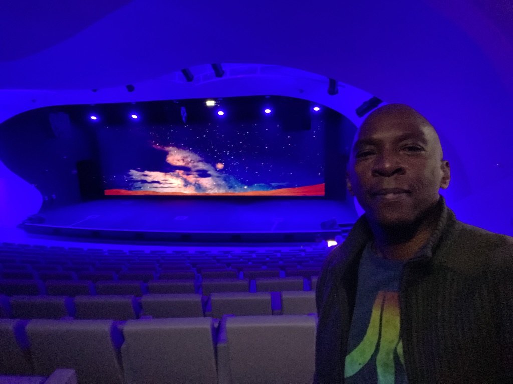 Boris Willis in the auditorium before a starfield scene on the stage screen