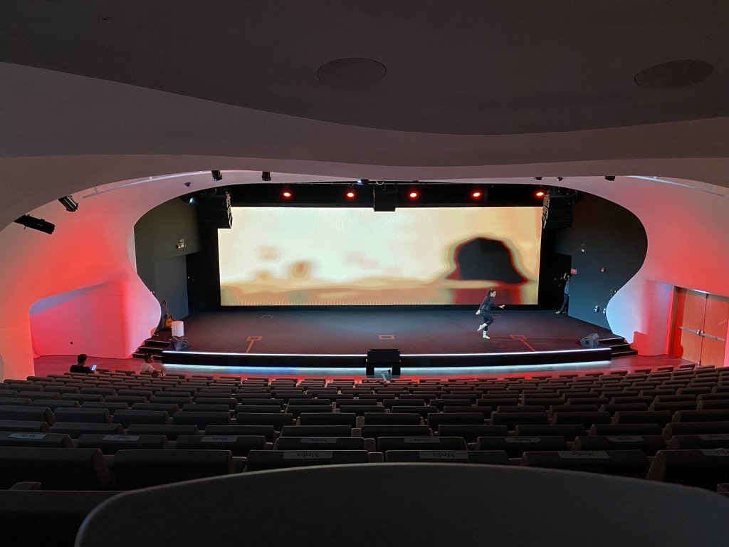 A single dancer on the Museum of the Future stage during a tech run