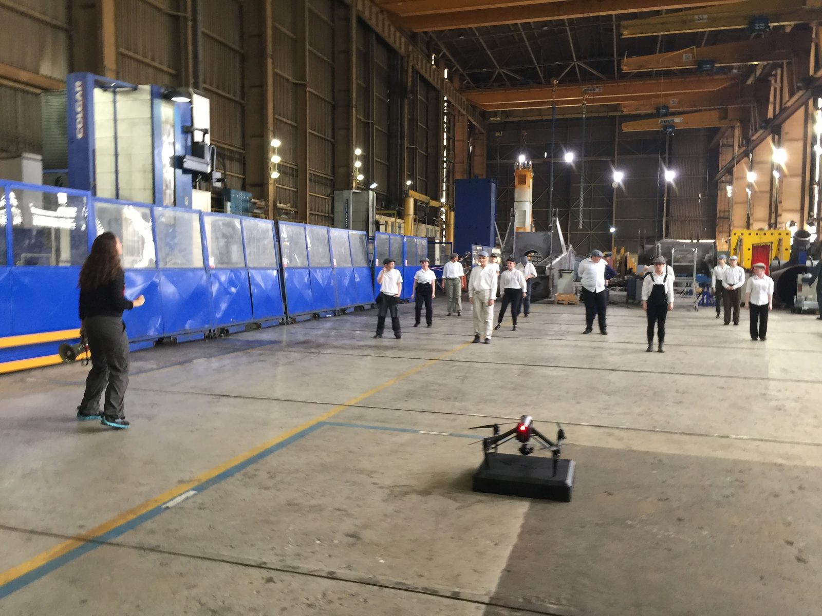 A director cues dancers as a drone sits grounded in the foreground
